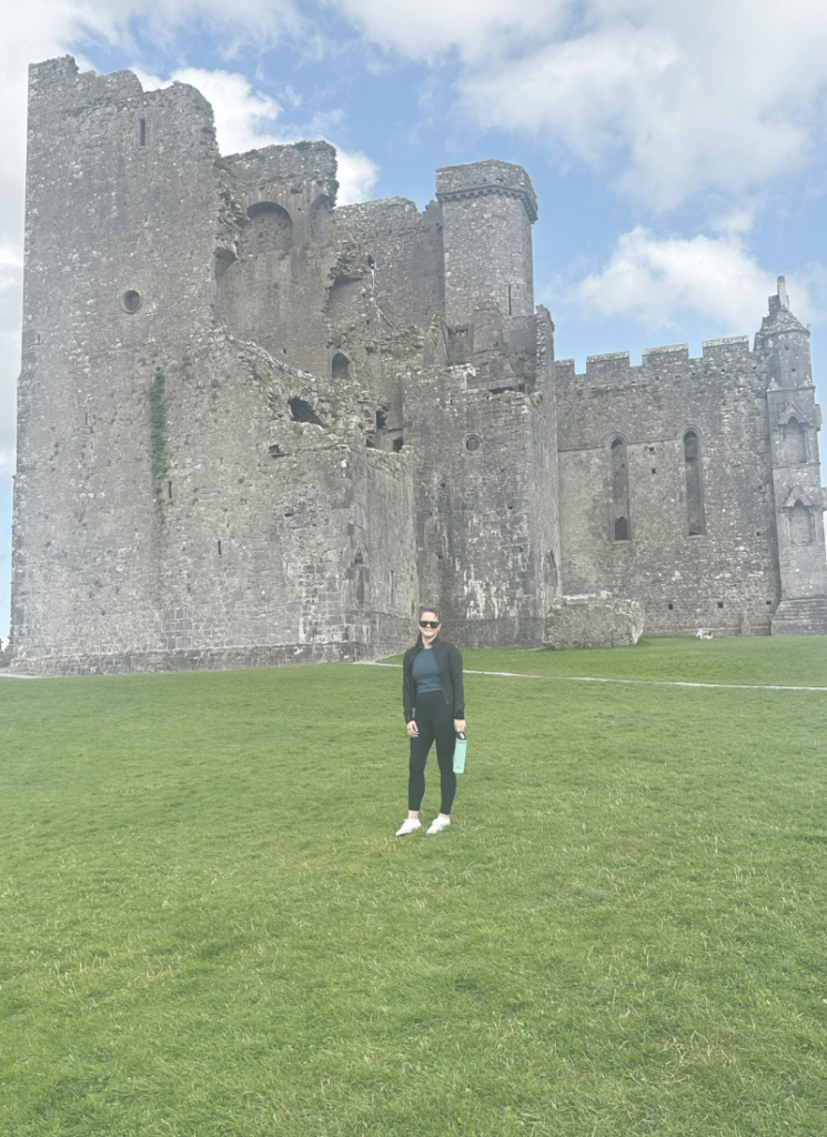 photo of myself standing in front of the rock of cashel in tipperary ireland, shared on my about me page.